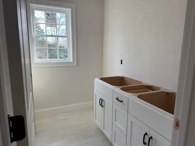 a kitchen with white cabinets and sink