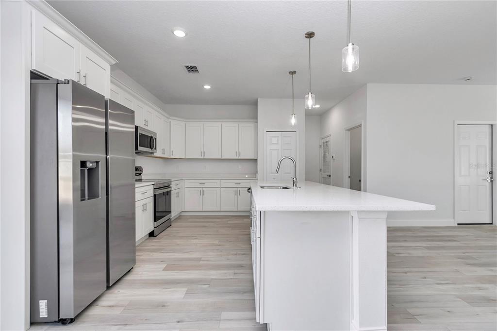 15227 Southwest 28th Avenue Road Ocala, FL 34473 - Photo 18 of 38 a kitchen with stainless steel appliances kitchen island a refrigerator sink and cabinets