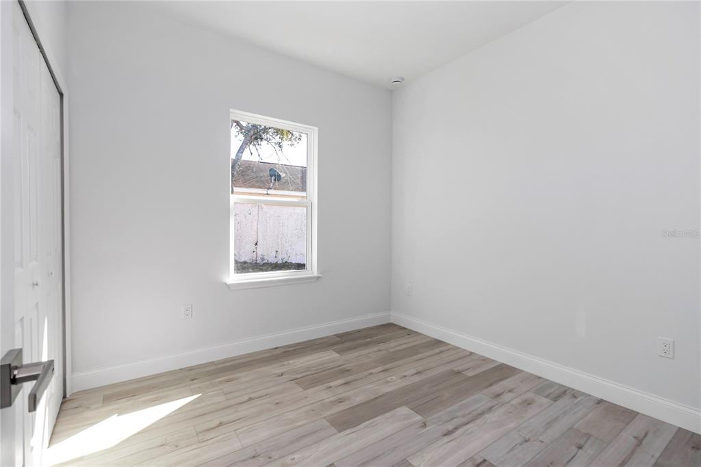 15227 Southwest 28th Avenue Road Ocala, FL 34473 - Photo 26 of 38 an empty room with wooden floor and windows