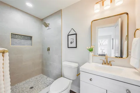 a bathroom with a sink a toilet and shower