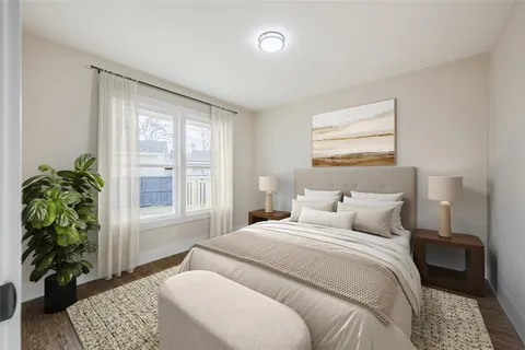 a bedroom with a bed plant and a window