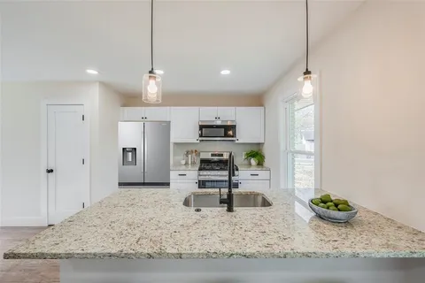 a kitchen with sink and refrigerator