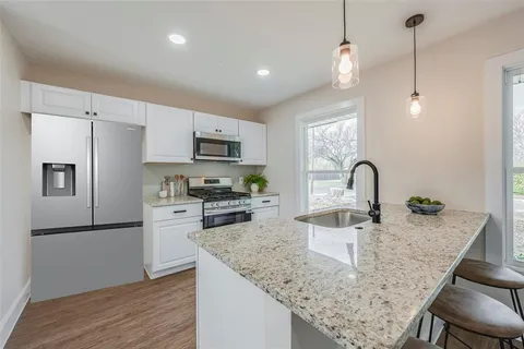 a kitchen with kitchen island a sink stove and refrigerator