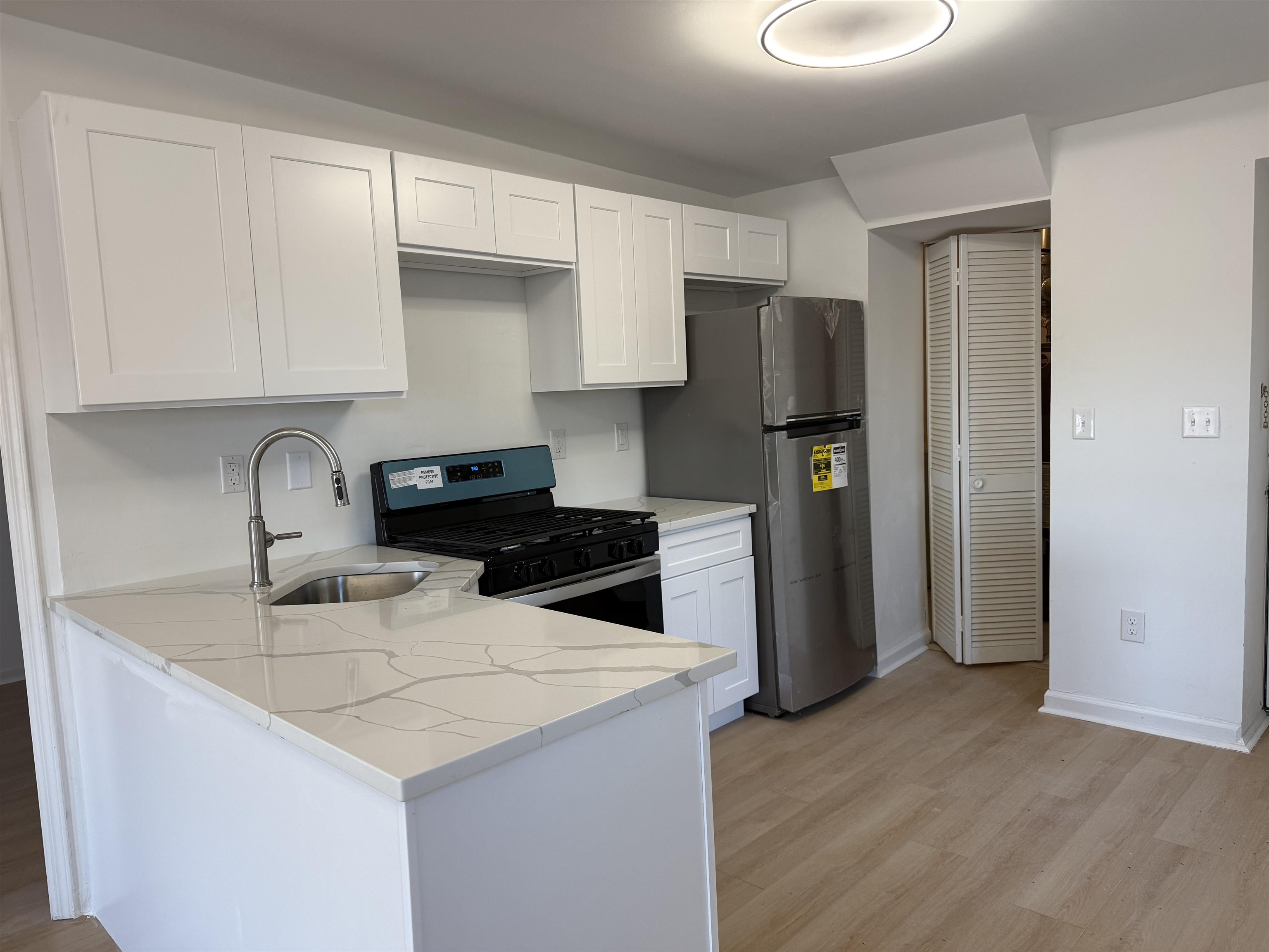 9007 Riverside Place, Unit 3 North Bergen, NJ 07047 - Photo 4 of 18 a kitchen with stainless steel appliances granite countertop a sink stove and refrigerator