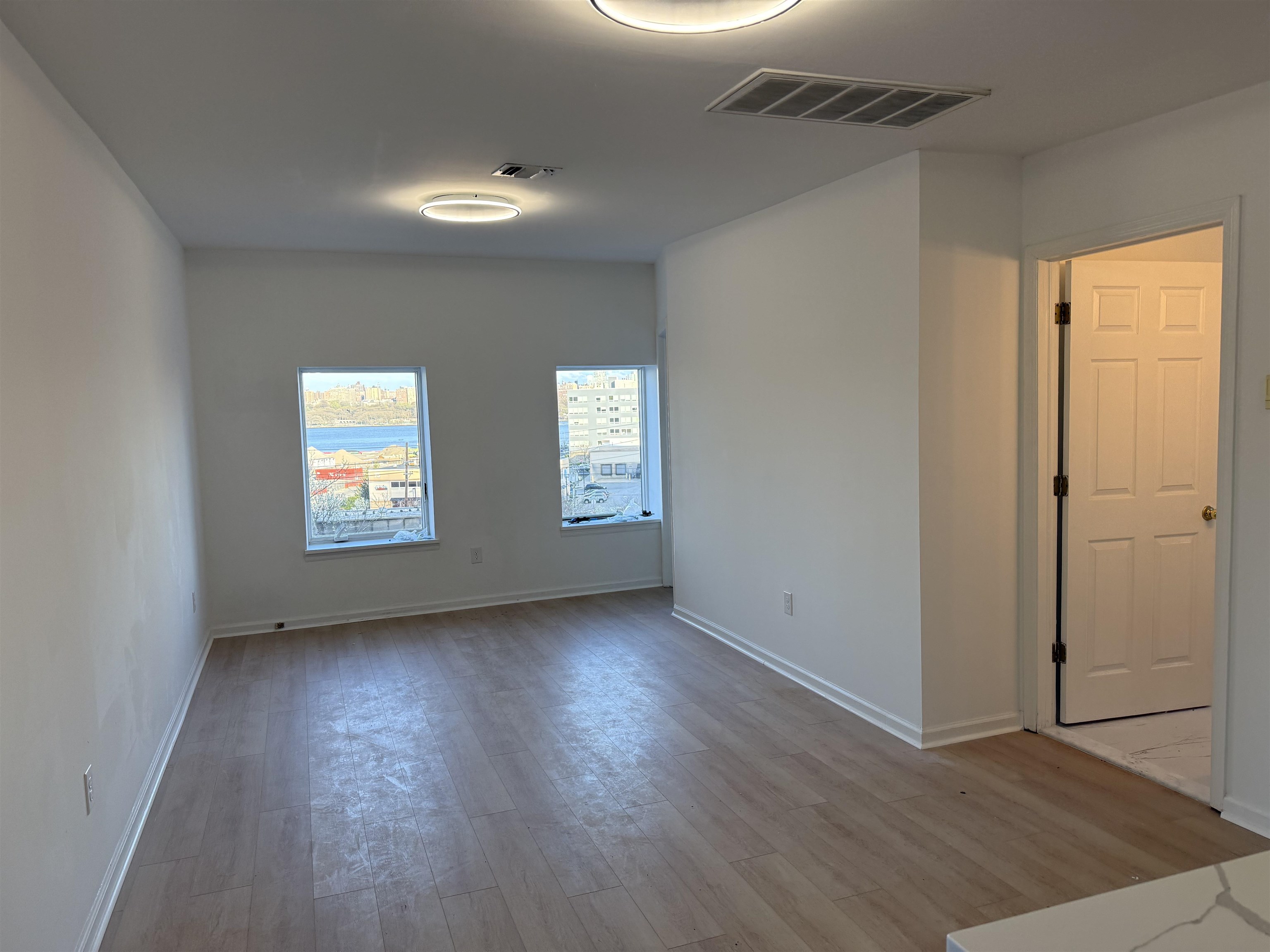 9007 Riverside Place, Unit 3 North Bergen, NJ 07047 - Photo 7 of 18 an empty room with wooden floor and windows