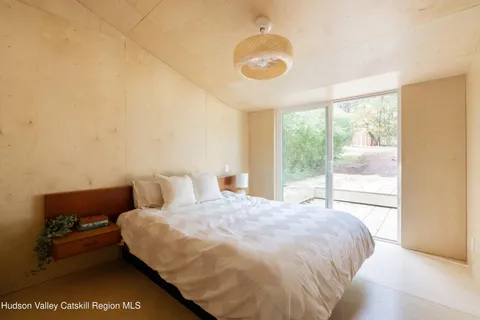 a bedroom with a bed and a large window