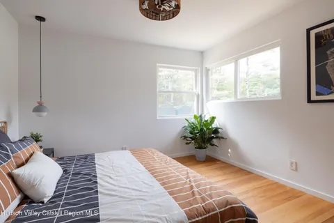 a view of a bedroom with wooden floor and a potted plant