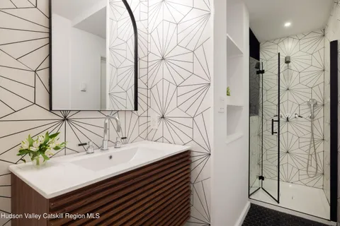 a bathroom with a sink and mirror with bathtub