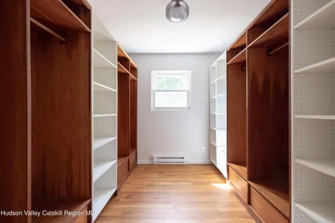 a view of a hallway with wooden floor and windows