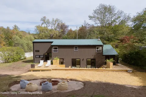 a view of a house with pool and chairs