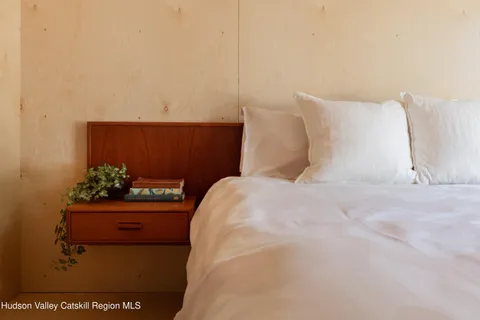 a bed sitting in a bedroom next to a window