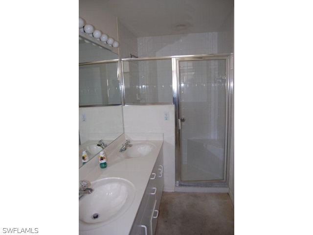 300 Robin Hood Circle, Unit 102 Naples, FL 34104 - Photo 6 of 8 a bathroom with a sink and a mirror