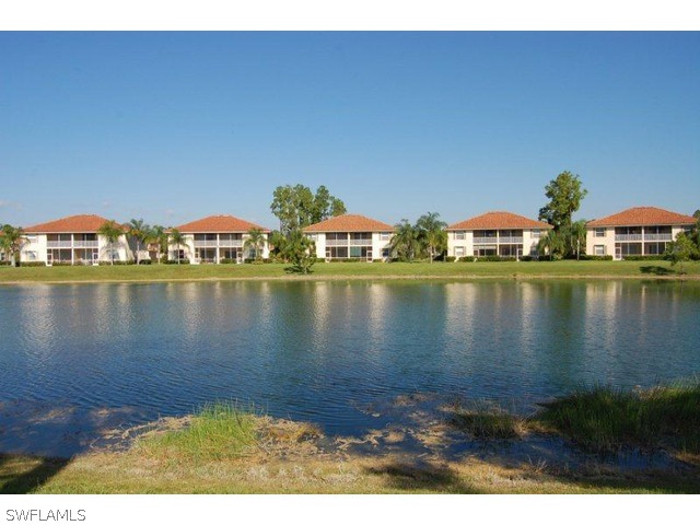 300 Robin Hood Circle, Unit 102 Naples, FL 34104 - Photo 8 of 8 a view of a lake with houses