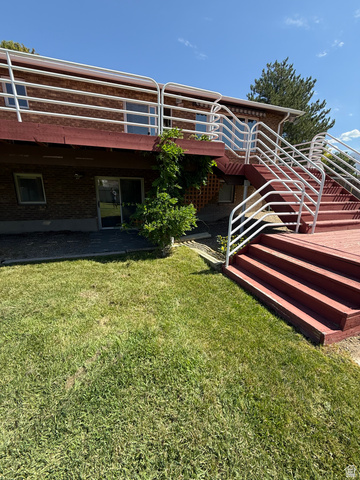 328 Heather Ridge Circle Sandy, UT 84070 - Photo 17 of 32 Brick exterior with a multi-level deck featuring white railings and red-stained wood steps