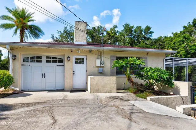 a view of a house with a yard and potted plants