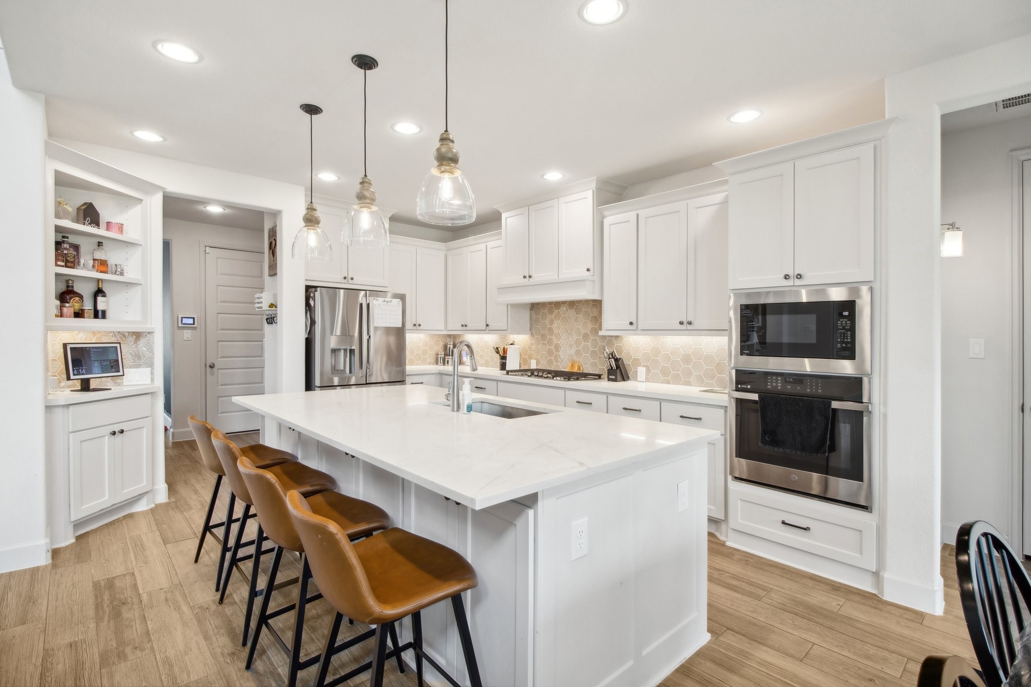 29819 Autumn Maple Court Fulshear, TX 77494 - Photo 11 of 47 a kitchen with stainless steel appliances granite countertop a stove a refrigerator a oven a white table and chairs with wooden floor