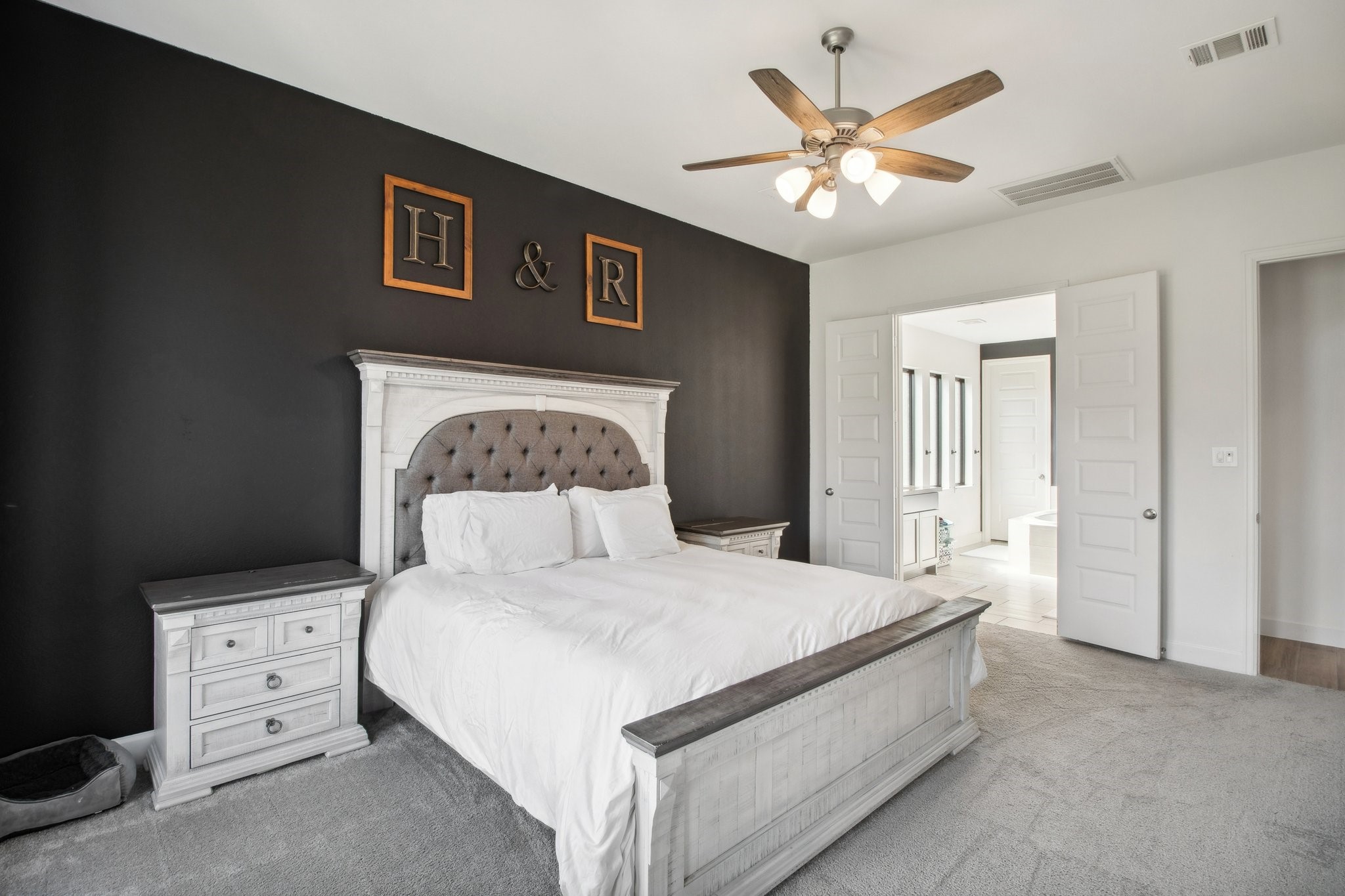 29819 Autumn Maple Court Fulshear, TX 77494 - Photo 27 of 47 a bedroom with a large bed and a chandelier