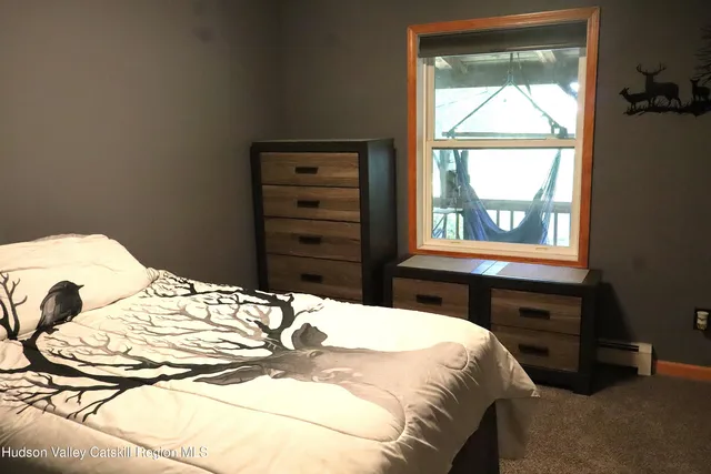 a bedroom with a bed and a dresser next to a window