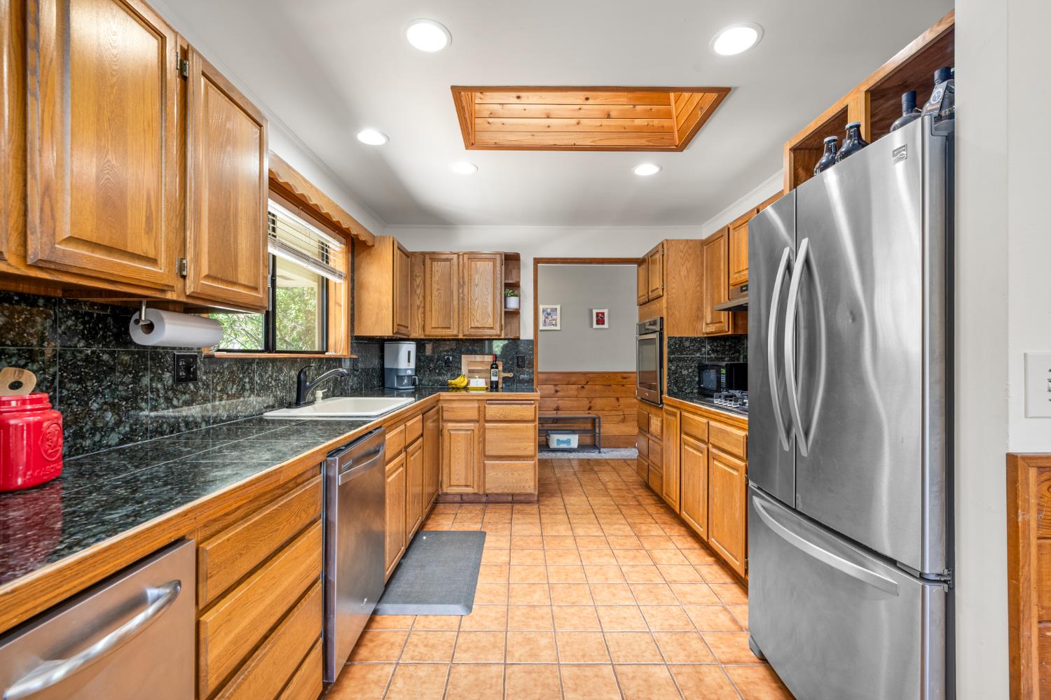 2162 Painted Pony Road Somerset, CA 95684 - Photo 11 of 72 a kitchen with stainless steel appliances granite countertop a refrigerator a sink dishwasher a stove with wooden cabinets and floor