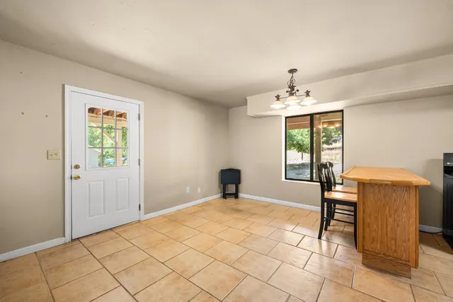 a view of a hallway with wooden floor and a bathroom
