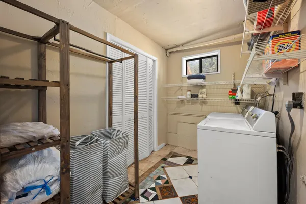 a view of a house with floor to ceiling windows and a tree
