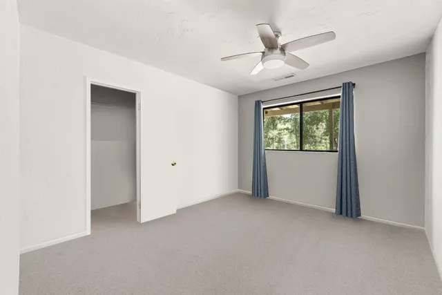 an aerial view of residential house with outdoor space and trees all around
