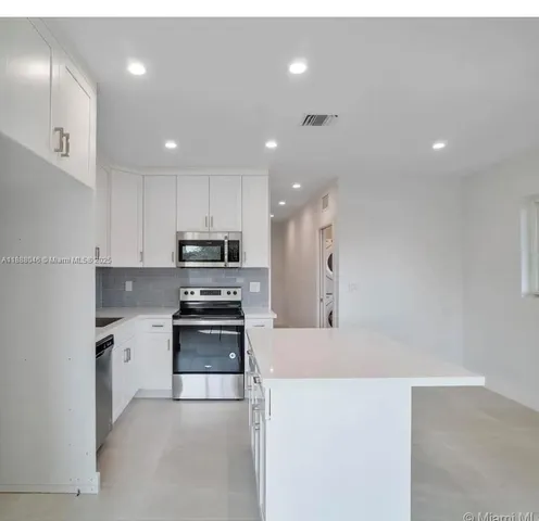 a kitchen with stainless steel appliances granite countertop a sink and a stove