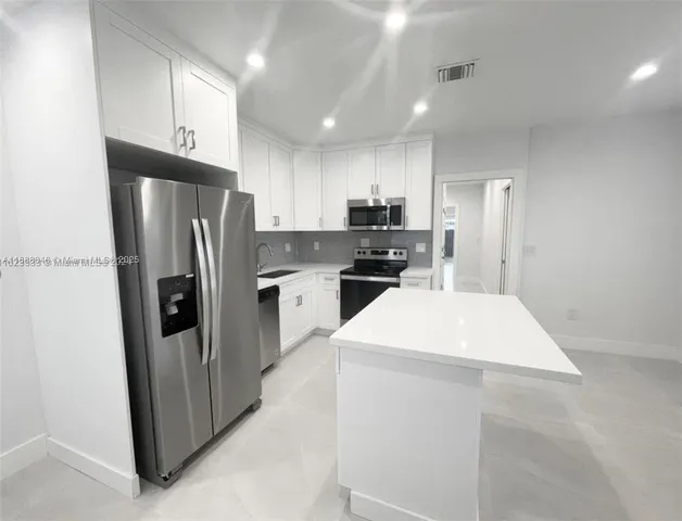 a kitchen with stainless steel appliances a refrigerator sink and microwave