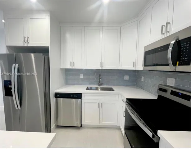 a kitchen with a sink stove and refrigerator