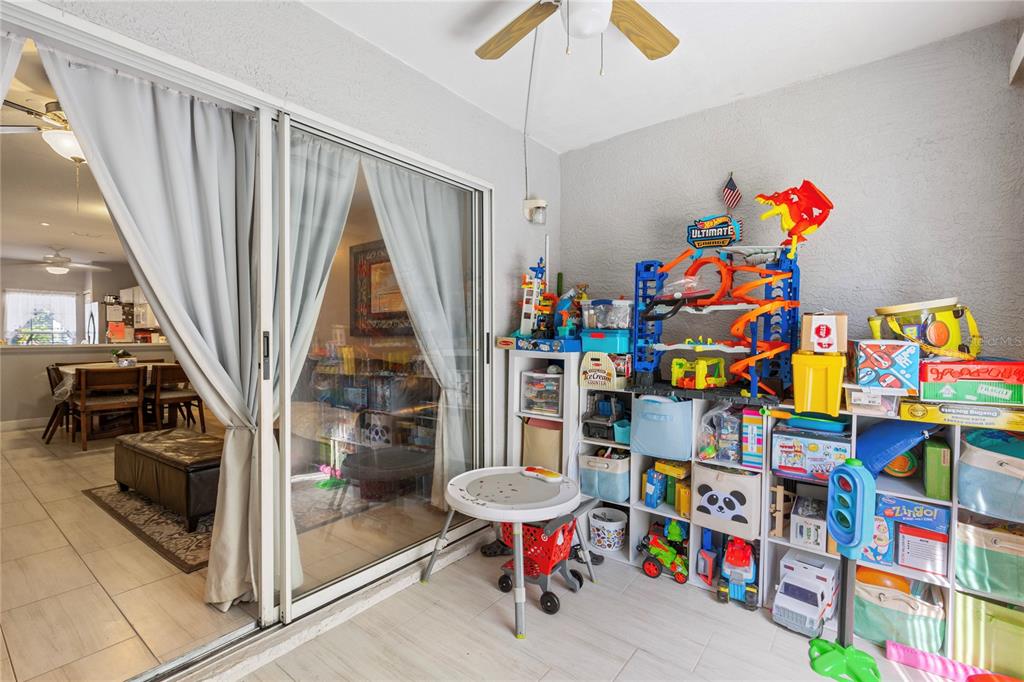 291 Countryside Key Boulevard Oldsmar, FL 34677 - Photo 21 of 34 a living room with lots of baby toys and a baby crib with wooden floor