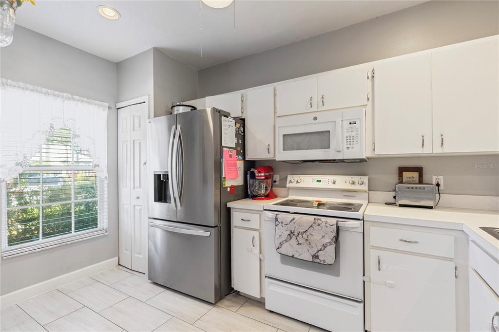 291 Countryside Key Boulevard Oldsmar, FL 34677 - Photo 3 of 34 a kitchen with white cabinets and white appliances