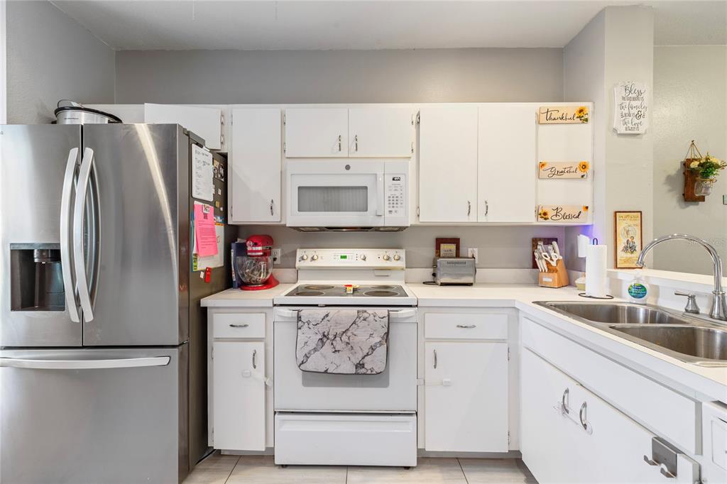 291 Countryside Key Boulevard Oldsmar, FL 34677 - Photo 4 of 34 a kitchen with stainless steel appliances a refrigerator sink and cabinets