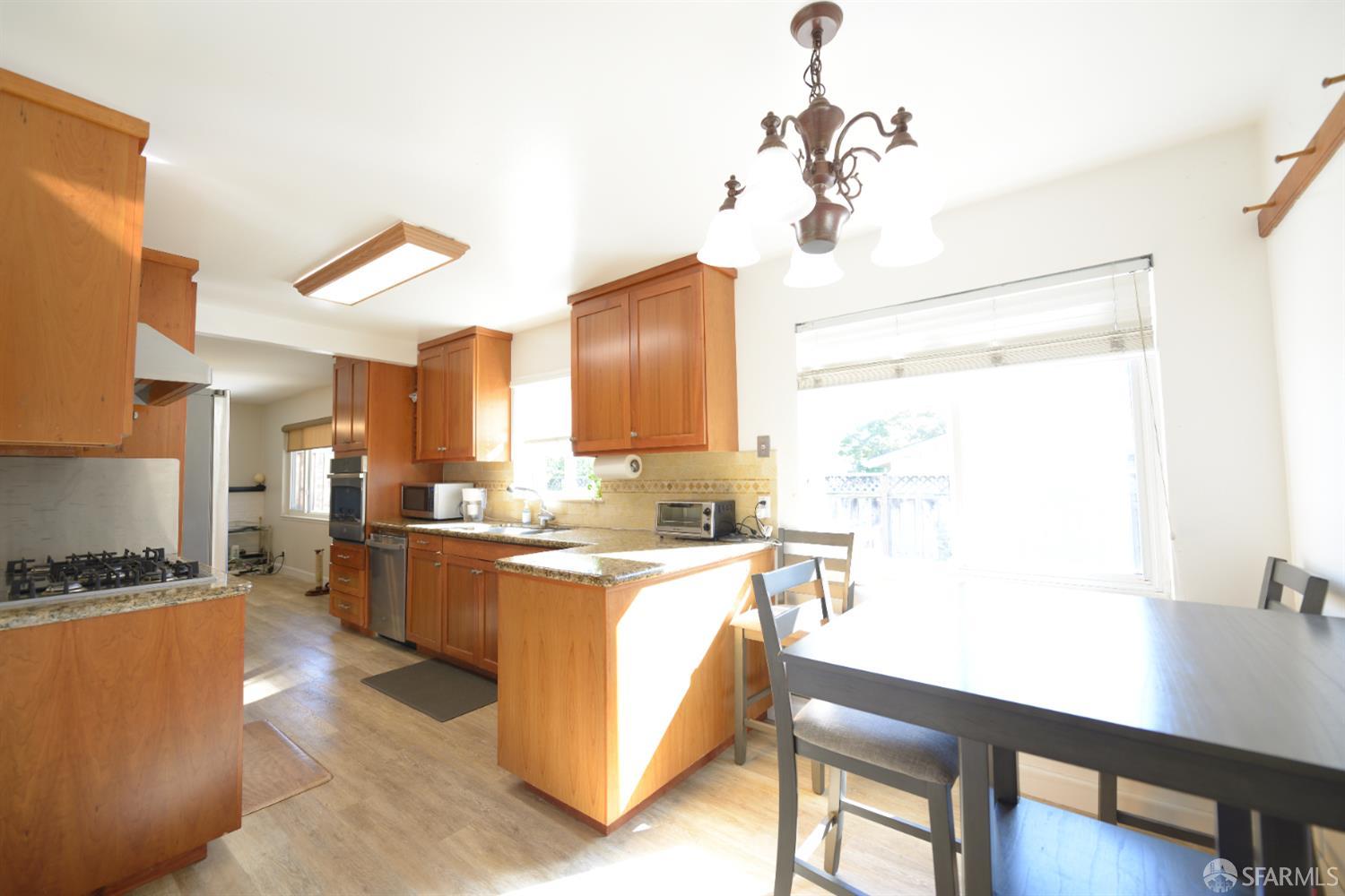 601 Garin Avenue Hayward, CA 94544 - Photo 22 of 27 a kitchen with a refrigerator a stove a sink dishwasher with a dining table and chairs