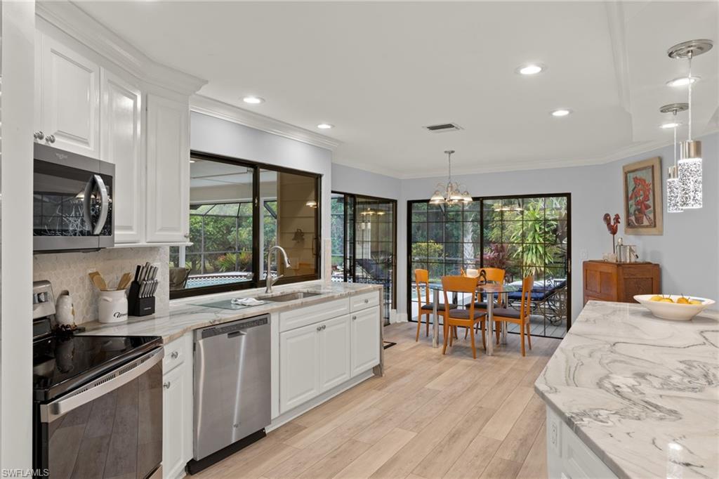 2259 Queens Way Naples, FL 34112 - Photo 13 of 29 a kitchen with stainless steel appliances granite countertop sink stove top oven and cabinets