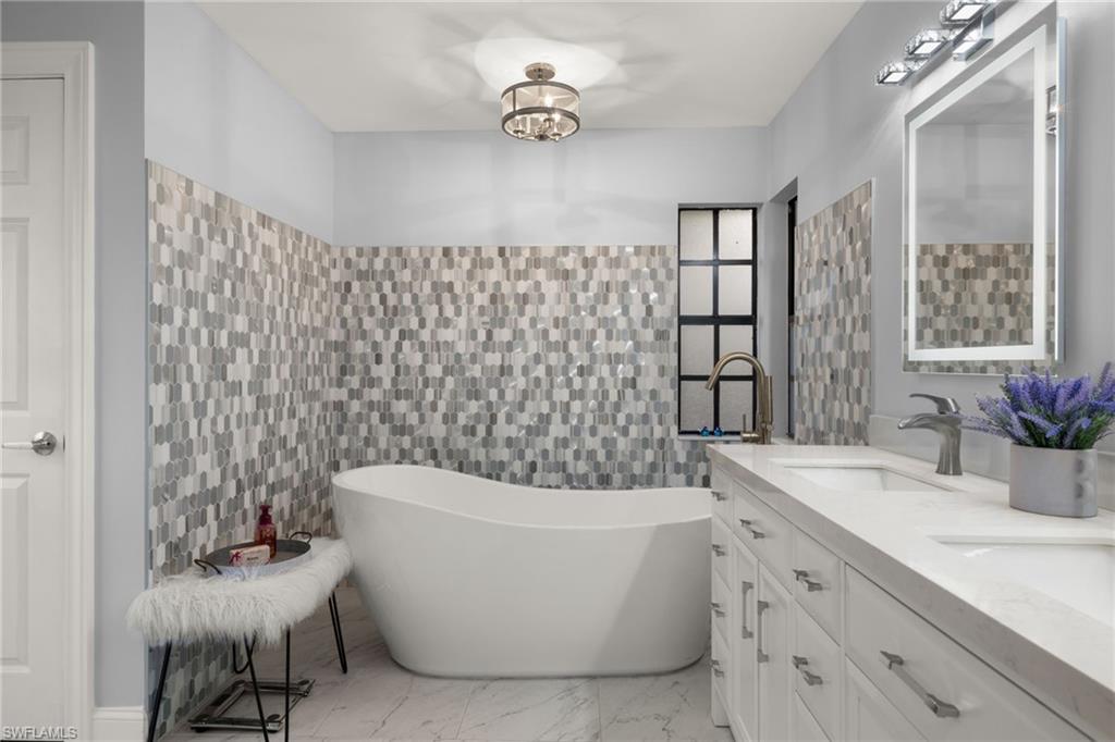 2259 Queens Way Naples, FL 34112 - Photo 19 of 29 a bathroom with a bathtub a sink and a shower