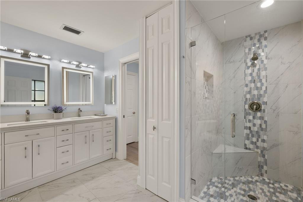 2259 Queens Way Naples, FL 34112 - Photo 21 of 29 a spacious bathroom with a double vanity sink mirror and shower