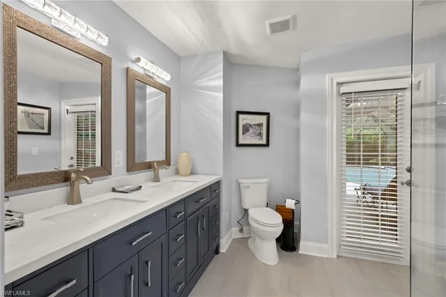 a bathroom with a double vanity sink and a window