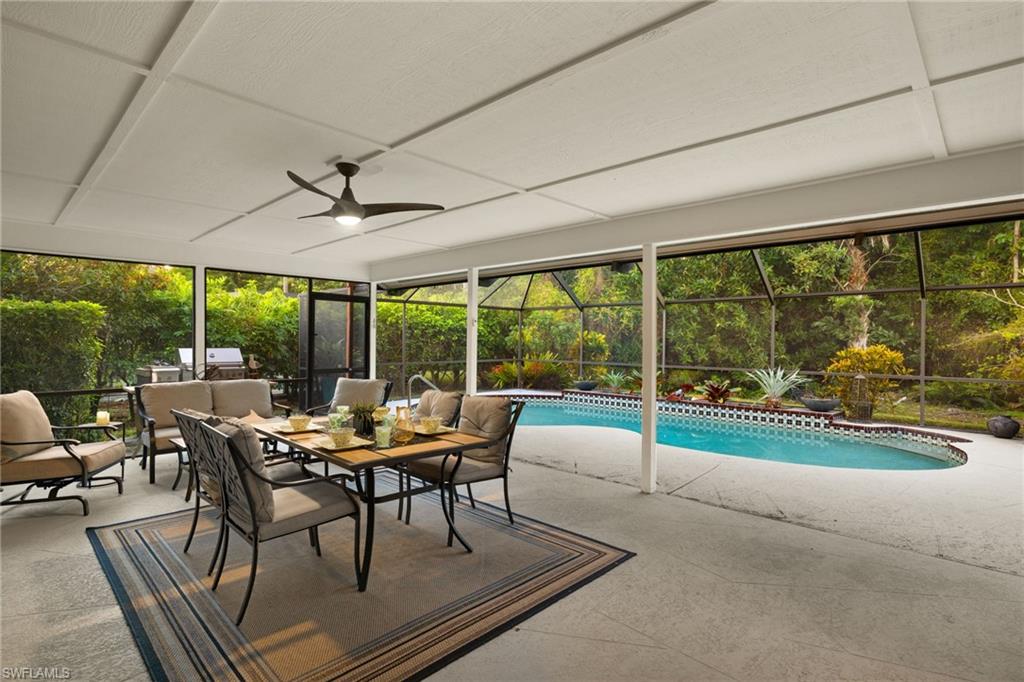 2259 Queens Way Naples, FL 34112 - Photo 25 of 29 a dining room with furniture large windows and wooden floor