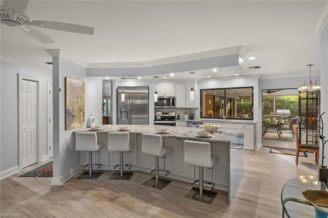 a kitchen with stainless steel appliances granite countertop a table and chairs in it