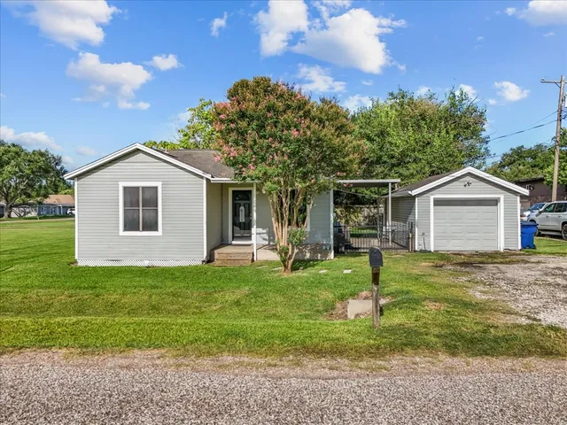 a front view of a house with a yard and trees