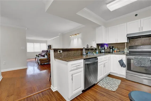 a kitchen with stainless steel appliances kitchen island granite countertop a refrigerator and a sink