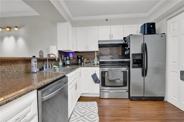 a kitchen with white cabinets and white appliances
