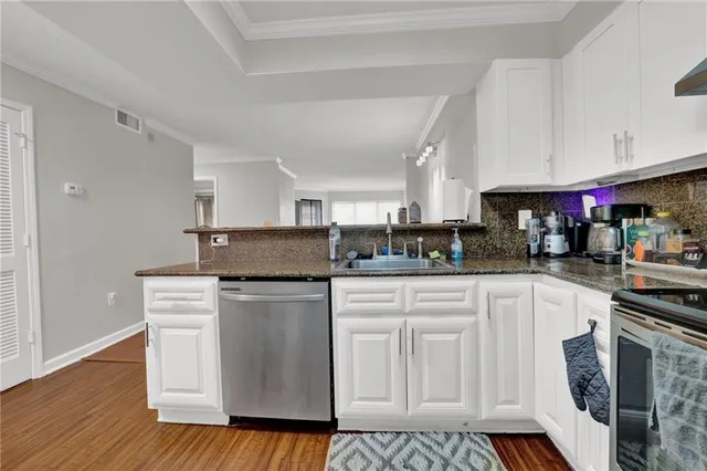 a kitchen with stainless steel appliances granite countertop a refrigerator and a stove top oven