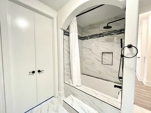 a bathroom with a glass shower door and a mirror