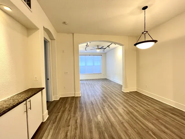a view of a room with wooden floor and entryway