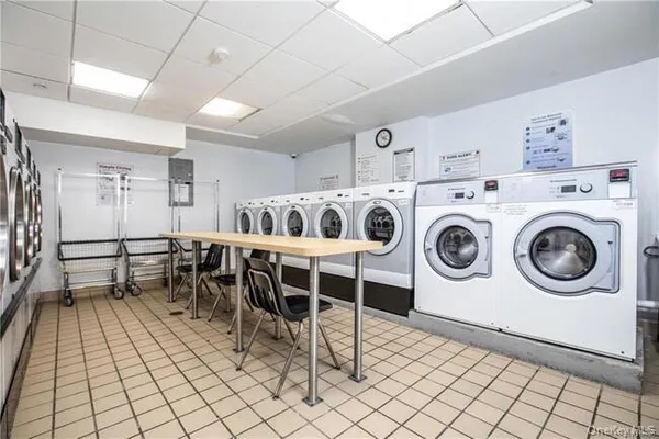 a utility room with dryer washer and a view of living room