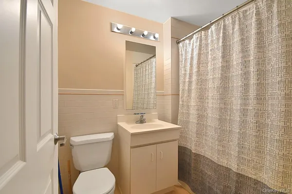 a bathroom with a toilet a sink and a mirror