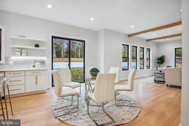 a view of a dining room and livingroom with furniture wooden floor and a chandelier