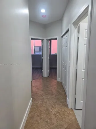 an empty room with closet and windows