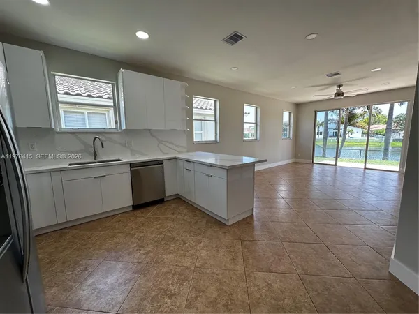 a large kitchen with stainless steel appliances granite countertop a sink and cabinets